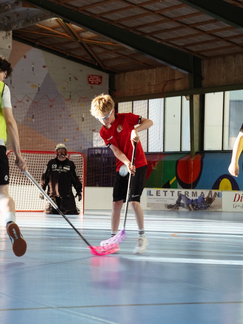 Tim im roten Trikot führt den Ball vor dem Tor