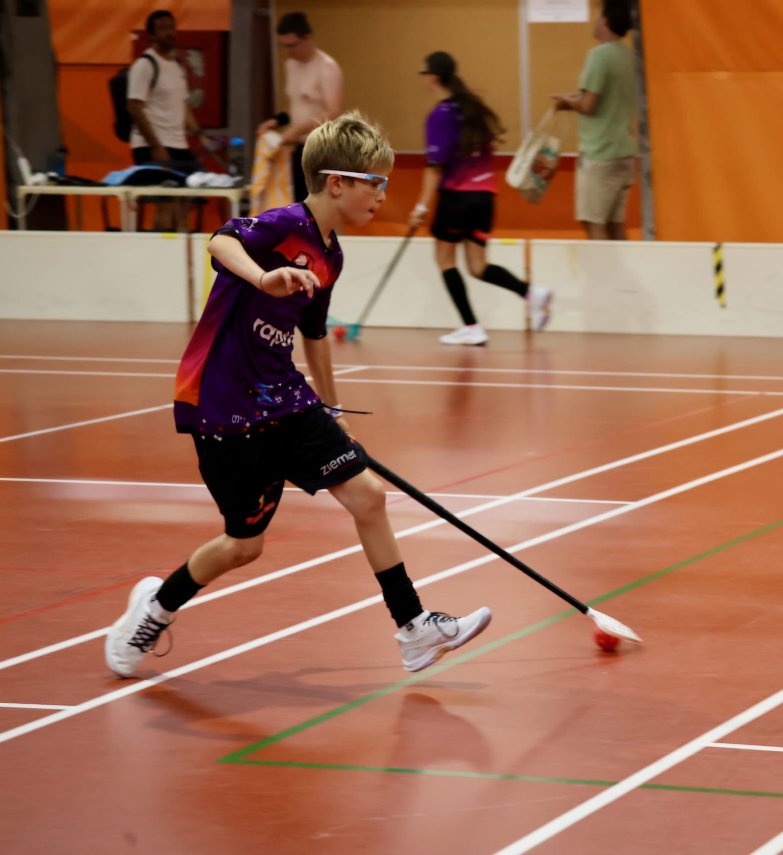 Tim im violetten Trikot sprintet mit dem Ball
